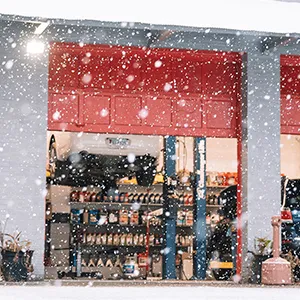 Snowy auto repair shop with open garage doors.